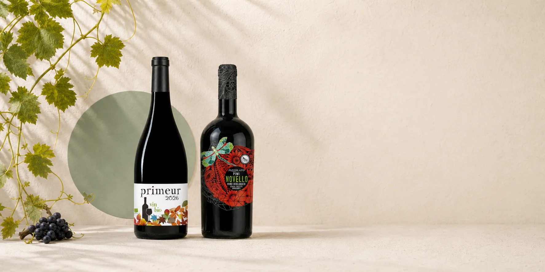 Primeur Merlot und Novello nebeneinander, dazu Trauben und Weinlaub